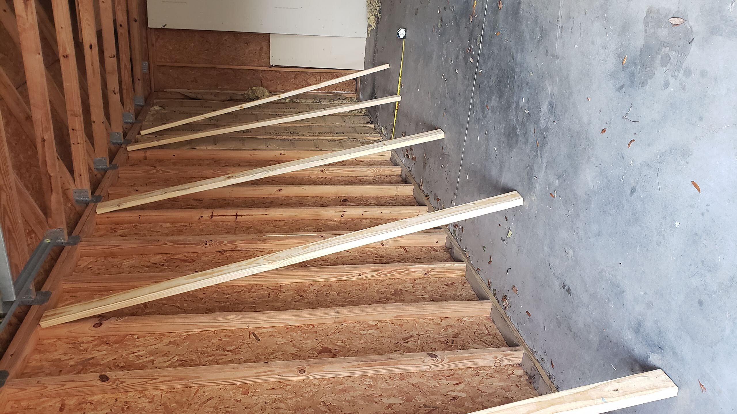 Unorganized garage storage space prior to custom shelving installation